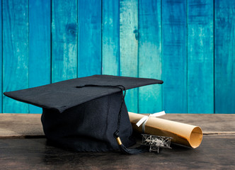 graduation cap, hat with degree paper on wood table, vintage woo