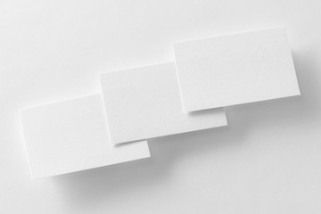 Wall Mural - Mockup of three business cards row at white textured paper