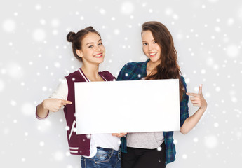 smiling teenage girls holding white blank board