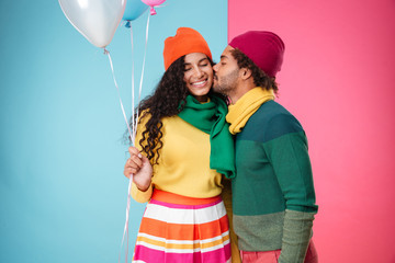 Wall Mural - Happy african young couple with balloons hugging and kissing