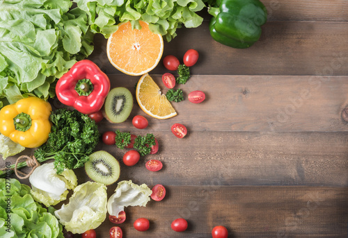 Obraz w ramie Fresh salad vegetables and fruit on wood background.