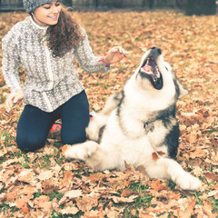 Image of young girl playing with her dog, alaskan malamute