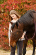 Mädchen mit Pferd vor Herbstlaub