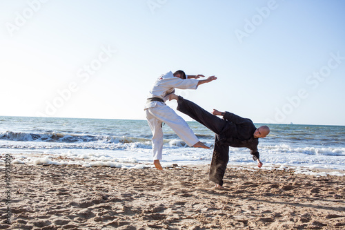 Fotomural karate sparing on the beach sea background