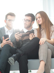 A group of young and happy young people using their phones and c