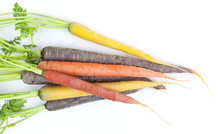 A Bunch Of Colorful Organic Carrots With Tops On A White Background. Horizontal