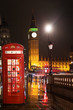 Popular tourist Big Ben and Houses of Parliament with red phone booth in night lights illumination in London, England, United Kingdom