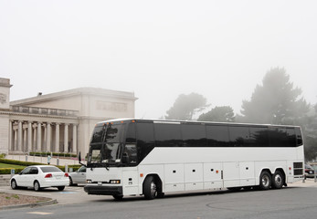 Tour charter bus parked outside of San Francisco's Legion of Honor with morning mist and fog. Horizontal.