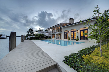 spectacular backyard swimming pool designer home. beautiful exterior of new home at twilight.