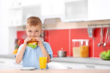 Wall Mural - Little boy having breakfast in the kitchen