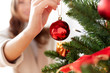 happy young woman decorating christmas tree