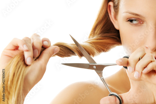 Plakat Atrakcyjna młoda kobieta jest cięcie jej długie, naturalne włosy
