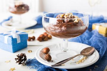 Wall Mural - Chocolate pudding mousse with avocado, nuts and holiday decorations. Delicious Christmas themed dinner table.