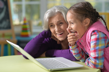 Canvas Print - Grandmother and granddaughter with laptop