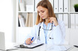 © rogerphoto - Female doctor  writing a medical prescription at clipboard