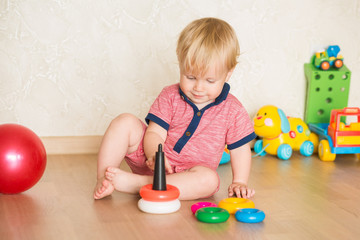 Year-old child playing with educational cup toys at home