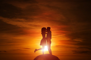 Silhouette of couple in love at the sunset with copy space