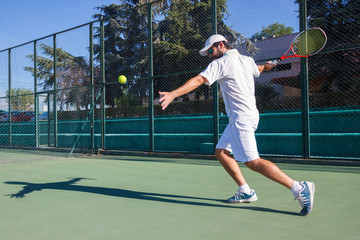 Wall Mural - Professional tennis player man playing on court