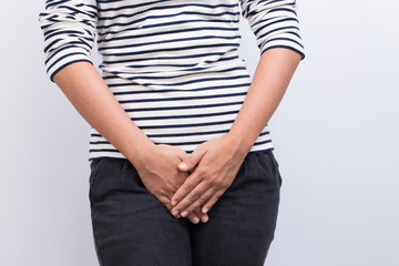 Woman with Hands Holding her Crotch Isolated in a White Backgrou