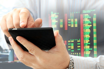 Poster - Close up of man using smartphone on stock market background