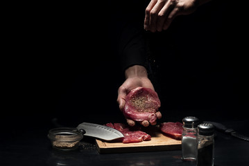 Close up of mans hands spicing the meat