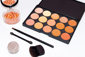 Set of decorative cosmetics for makeup.Eye shadows , concealers, blush and makeup brushes on a light background.