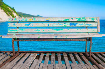 Old rusty bench at pier in the sea