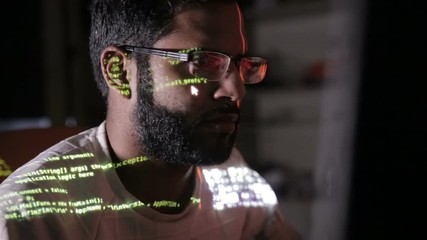 Male hacker works on a computer with data on screens. HD.