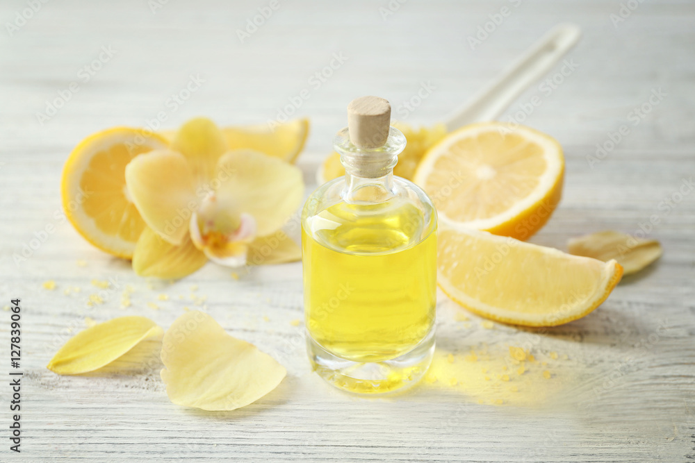 Beautiful spa composition with lemon essential oil on white wooden background, closeup