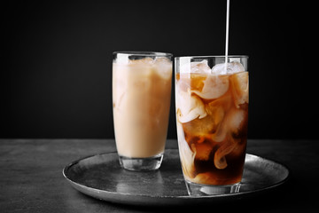 Canvas Print - Pouring milk in iced coffee on grey background