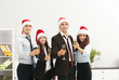 © Africa Studio - Business people in Santa hats at office party