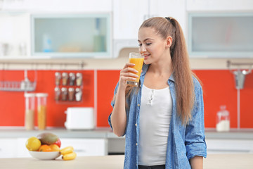 Poster - Young beautiful  woman  in kitchen drinking juice