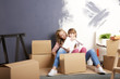 © sepy - Moving into a new home. Shot of a cute girl helping to unpack the cardboard box to her mother while sitting their new home.