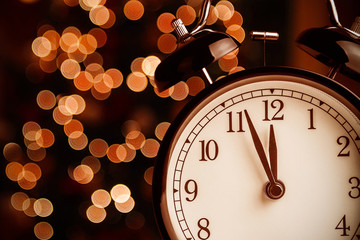 Wall Mural - vintage alarm clock is showing midday or midnight. It is twelve o'clock, christmas and bokeh, holiday happy new year festive concept