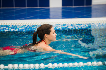 Smiling portrait of beautiful woman in swimming pool