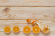 on a wooden table at the bottom lay sliced tangerines