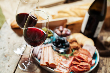 Red wine with charcuterie assortment on the background