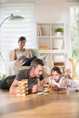 Cheerful family at home, Daddy playing with his daughter