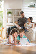© jackfrog - Cheerful family at home. two kids playing with a digital tablet