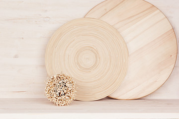 Soft home decor of  wooden plate and stems on white wood background. Interior.