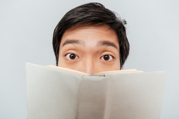 Canvas Print - Asian man from behind a book