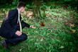 © IVASHstudio - young and handsome groom sitting near squirrel in the park