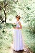 © IVASHstudio - young beautiful bride in a white dress standing alone outdoors