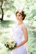 © IVASHstudio - young beautiful bride in a white dress standing alone outdoors