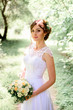 © IVASHstudio - young beautiful bride in a white dress standing alone outdoors