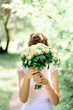 © IVASHstudio - bride hiding behind a wedding bouquet of flowers