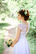 © IVASHstudio - young beautiful bride in a white dress standing alone outdoors