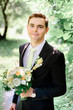 © IVASHstudio - young handsome groom in a black suit standing alone outdoors