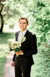 © IVASHstudio - young handsome groom in a black suit standing alone outdoors
