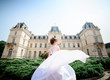 © IVASHstudio - young and beautiful bride in white dress walks near manor